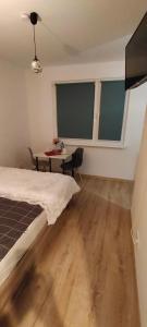 um quarto com uma cama, uma mesa e janelas em Apartament Sosnowiec - Kazimierz Górniczy em Sosnowiec