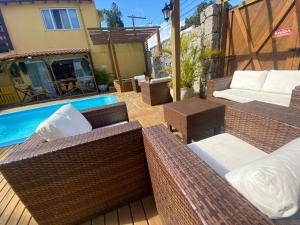 un patio con muebles de mimbre junto a una piscina en Hotel Fênix, en Florianópolis