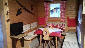 ein Puppenhaus-Zimmer mit einem Tisch und einem TV in der Unterkunft Berghütte Graslehn in Jerzens