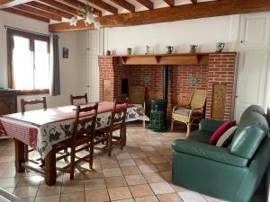 - un salon avec une table, des chaises et une cheminée dans l'établissement Chez ma tante, à Méneslies