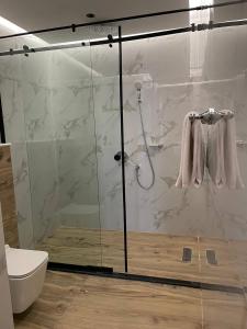 baño con ducha y puerta de cristal en شرفة en Riad