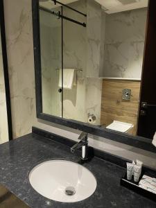 uma casa de banho com um lavatório e um espelho em شرفة em Riade