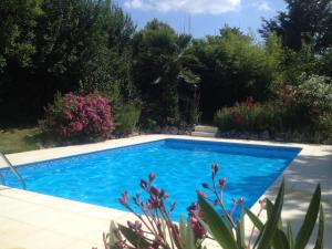 einen Pool in einem Garten mit Blumen in der Unterkunft Grande maison atypique in Le Burgaud