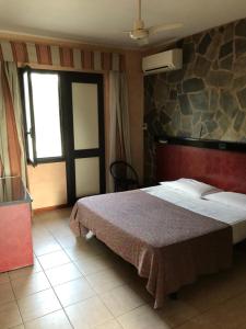 a bedroom with a bed and a stone wall at American Motel in Cisterna di Latina