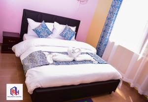 een slaapkamer met een bed met twee knuffels erop bij Belmont Hotel Homabay in Homa Bay