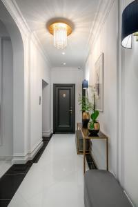 a hallway with a black door and a chandelier at Praxitelous Luxury Suites in Athens