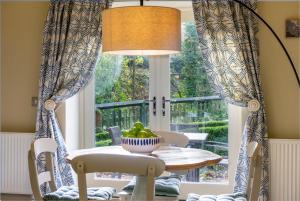 jadalnia ze stołem i oknem w obiekcie Gardeners Cottage w mieście Sandsend