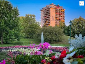 budynek z fontanną w parku z kwiatami w obiekcie Parkblick - Therme Wien - gratis Parken im der Garage - Terrasse - U-Bahn w Wiedniu