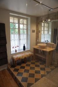 a bathroom with a sink and a checkered floor at La Maison du Gardien, Chateau de lAvenue in Pierrefitte-en-Auge