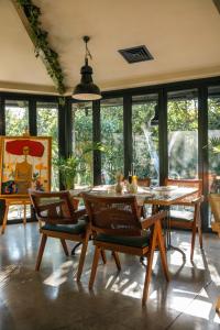 comedor con mesa, sillas y ventanas en Hotel Garden, en Pristina