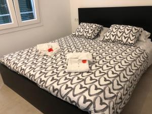 a bed with black and white sheets and towels on it at Atalaya de Fornells in Fornells