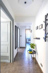 a hallway with white walls and a table at Hostly - Nicole Apartment Volturno- Full Rome Center in Rome