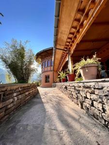 a building with a stone wall and potted plants on it at Rema Resort in Paro