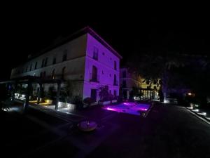 un edificio con luci viola di fronte ad esso di notte di Appartment Nazari in Velez de Benaudalla a Vélez de Benaudalla