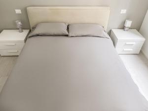 ein Schlafzimmer mit einem weißen Bett und zwei Nachttischen in der Unterkunft BNB Capital Milano Moscova - White in Mailand