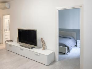 ein weißes Wohnzimmer mit einem TV und einem Spiegel in der Unterkunft BNB Capital Milano Moscova - White in Mailand