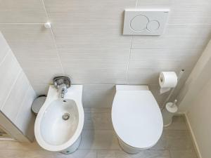 ein kleines Bad mit einem WC und einem Bidet in der Unterkunft BNB Capital Milano Moscova - White in Mailand