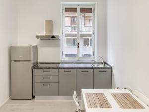 eine Küche mit einem Kühlschrank und einem Fenster in der Unterkunft BNB Capital Milano Moscova - White in Mailand
