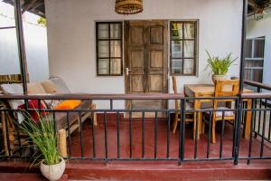 a balcony with a table and chairs and a door at Blue elephant villas in Arusha