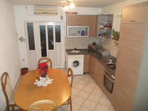a kitchen with a wooden table and a table and chairs at Apartment Matej in Senj