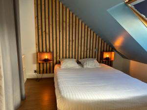 a bedroom with a large white bed with two lamps at Le Cocon Gambetta in Reims