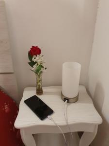 una mesa con un jarrón de flores y una vela en Casa medievale Il Rifugio di Olimpia en Viterbo