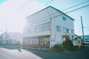 un edificio blanco al lado de una calle en ゲストハウス＆カフェバー　エストアール, en Shibetsu