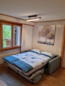 1 dormitorio con 1 cama con una foto en la pared en Gemütliche Ferienwohnung zwischen See und Bergen, en Brienz