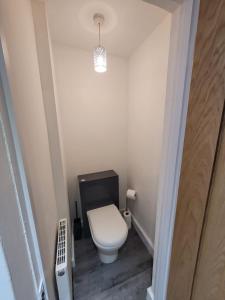 a small bathroom with a toilet and a light at Handpost Retreat in Newport