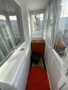 a small room with two windows and a red rug at Central Park Studio in Piatra Neamţ +27 photos