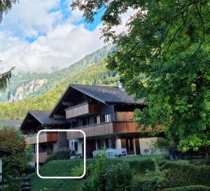 una casa con una montaña en el fondo en Gemütliche Ferienwohnung zwischen See und Bergen, en Brienz