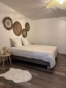una camera da letto con un letto con due cappelli appesi al muro di La kazanou a Saint-Joseph