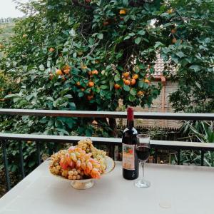 una botella de vino y un bol de fruta en una mesa en Kizikis Kari, en Signagi
