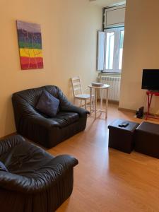uma sala de estar com um sofá de couro e uma mesa em Alojamento Porta10 em Sertã
