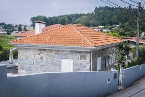 ein Backsteinhaus mit einem orangefarbenen Kacheldach in der Unterkunft Vivenda Mendes 2 in Vila Nova de Famalicão