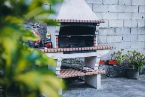 un horno de pizza al aire libre junto a una pared de ladrillo en Vivenda Mendes 2 en Vila Nova de Famalicão