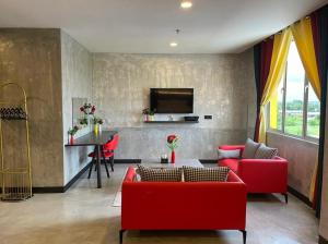 a living room with red couches and a table at Sri Indar Hotel & Suites in Parit Buntar