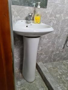 lavabo blanco en el baño con espejo en Unia fancy flats - studio apartment two en Kampala