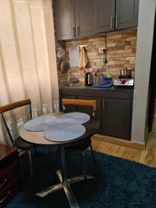 cocina con mesa, 2 sillas y barra en Unia fancy flats - studio apartment two en Kampala
