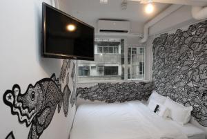 una camera con letto e TV a parete di Hop Inn a Hong Kong