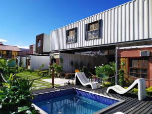 una casa con piscina al lado de un edificio en Container Eco Suítes, en Cabo Frío