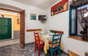 ein Esszimmer mit einem Tisch und Stühlen in der Unterkunft Amazing Home In Susak With 2 Bedrooms And Wifi in Susak