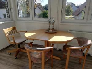 a table and chairs in a room with windows at Ferienhaus Königs Wusterhausen in Königs Wusterhausen