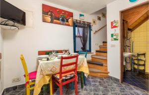 a dining room with a table with chairs and a television at Stunning Home In Susak With Kitchen in Susak