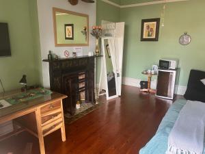 a living room with a fireplace and a desk at Sunny private room on the porch in Port Elizabeth