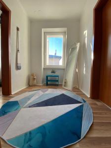 Apartman Ancoris في نوفي فينودولسكي: غرفة بها سجادة زرقاء وبيضاء على الأرض