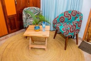 a living room with a chair and a table with a plant at Blue elephant villas in Arusha +61 photos