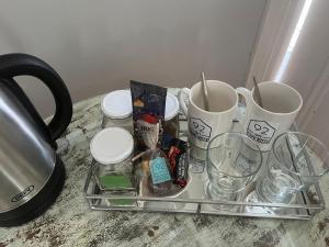 a tray with cups and glasses on a counter at Sunny private room on the porch in Port Elizabeth