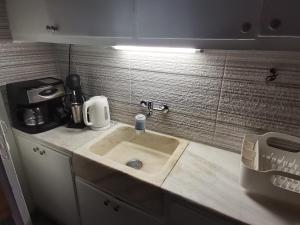 um lavatório de cozinha com uma luz por cima em Penthouse spacious w super wifi & terrace, 2 min from metro em Atenas