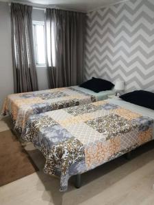 two beds sitting next to each other in a bedroom at Vivenda Mendes in Outeiro